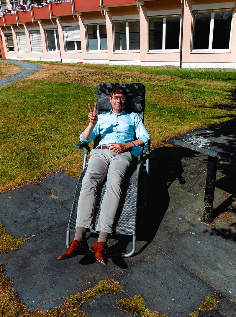 Lothar genießt die Pause in der Sonne auf einer Liege und streckt zwei Finger zum Victory-Zeichen hoch.