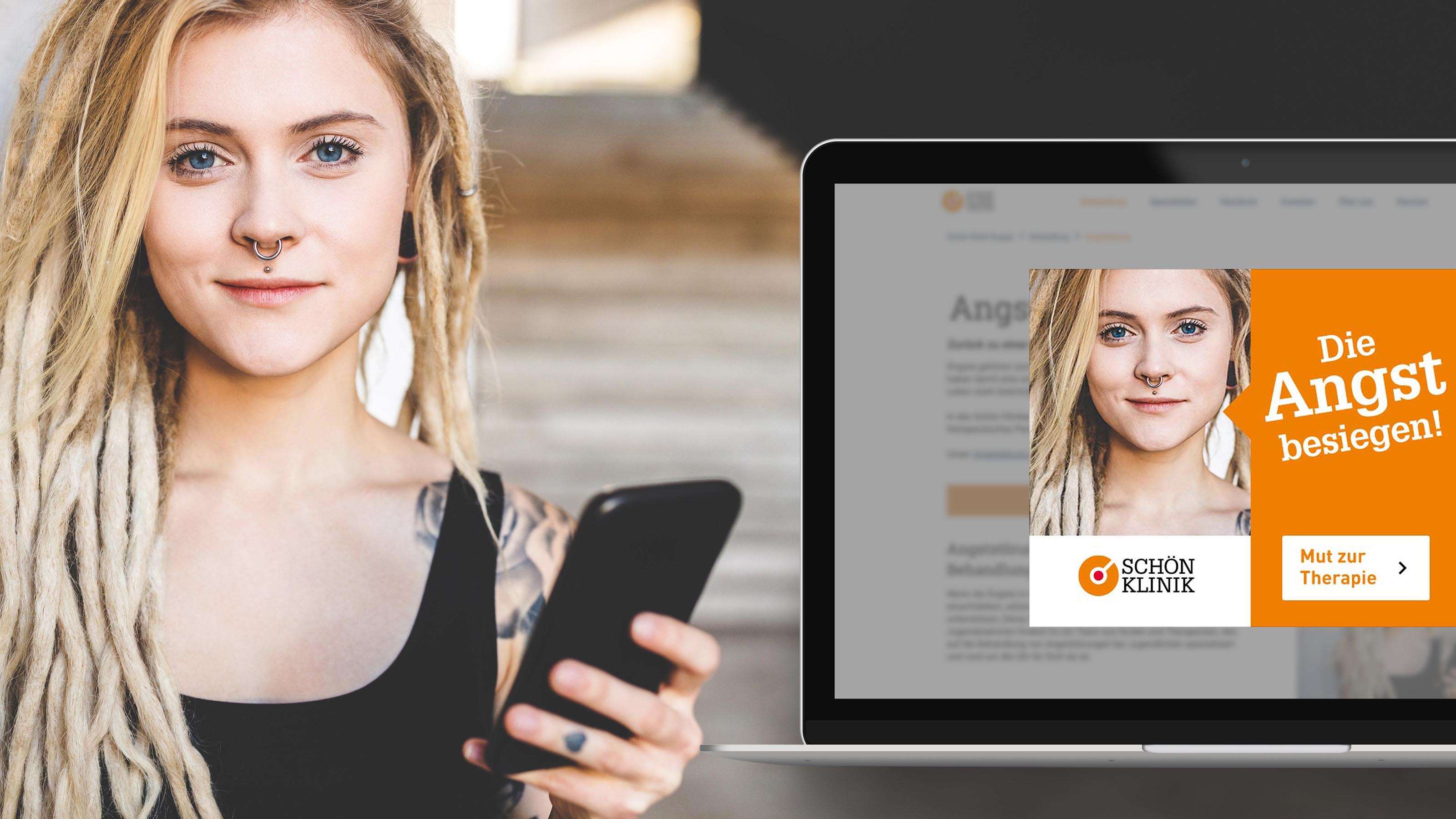 Eine junge Frau mit blonden Dreadlocks, einem Nasenpiercing und einem Tattoo an der Schulter steht mit Smartphone in der Hand neben einem leuchtend orangenen Mockup der Website der Schön Klinik mit einem Popup der Kampagne „Die Angst besiegen“ in einem MacBook.